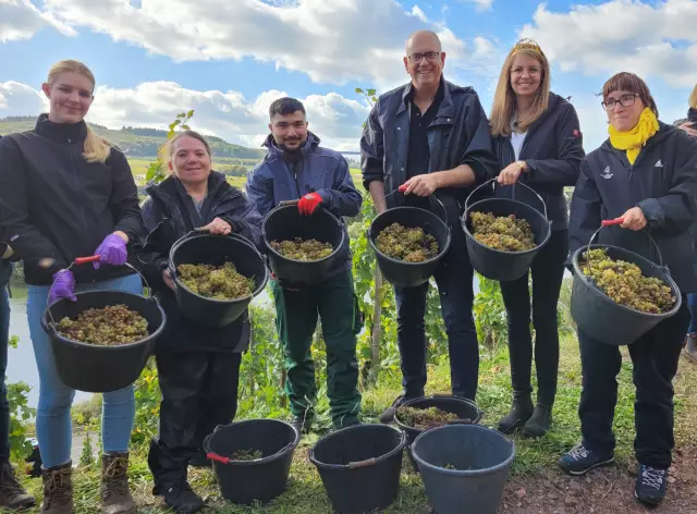 Martina Sanowski-Lütjen und ihr Team vom Martinshof, Bremens Bürgermeister Dr. Andreas Bovenschulte und die Deutsche Weinkönigin Eva Brockmann (Zweite von rechts) freuen sich über die erfolgreiche Senatsweinlese im Bremer Weinberg an der Mosel. Foto: Senatspressestelle